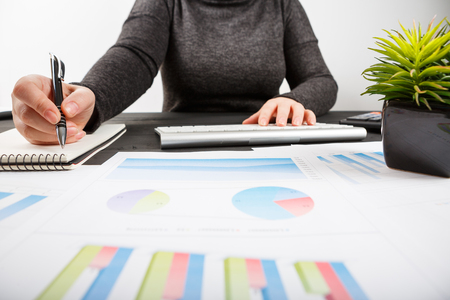 Close up of female accountant or banker making calculations. Savings, finances and economy conceptの写真素材