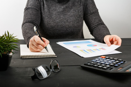 Close up of female accountant or banker making calculations. Savings, finances and economy conceptの写真素材