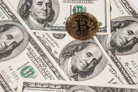 New virtual money Golden bitcoin coin on us dollars background . Cryptocurrency. Business and Trading concept.の写真素材