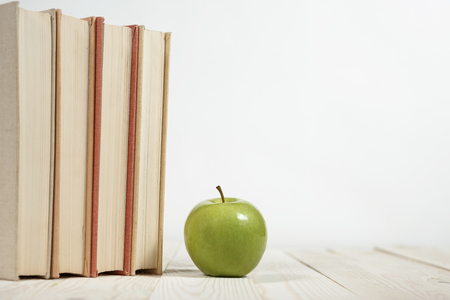 Stack of books and apple on the table. Copy space for text. Selective focus. Knowledge conceptの写真素材