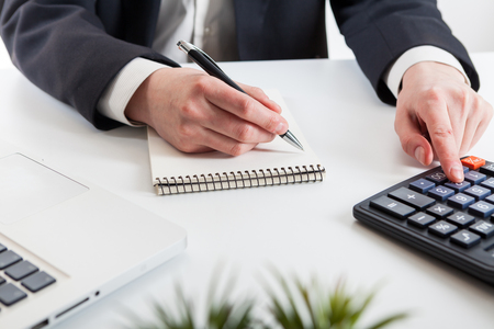 Close up view of bookkeeper or financial inspector hands making report, calculating or checking balance. Marketing strategy brainstorming. Paperwork and digital in office.の写真素材