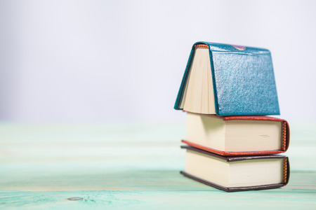 Pile of miniature books on wooden background. With copy space for your textの写真素材