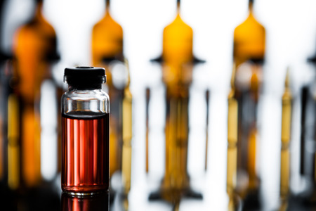 Production of medicines. lot of ampoules on light background. Group of ampoules with a transparent medicine in medical laboratoryの写真素材