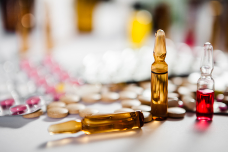 On the table there are ampoules next different pills drugs and medications. With copy space for your textの写真素材