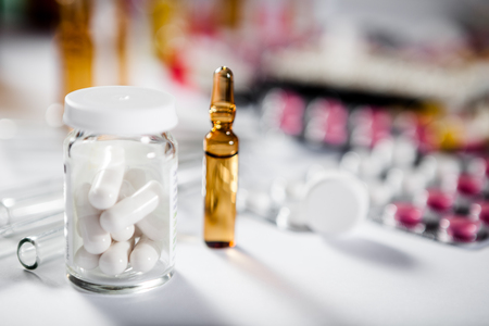 On the table there are ampoules next different pills drugs and medications. With copy space for your textの写真素材