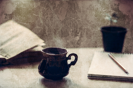 Cup of fresh coffee  with old book on wooden table. Grunge strip background. Selective focus. の写真素材