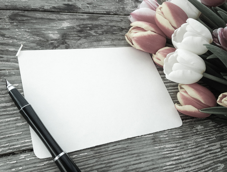 Tulips flowers bunch on dark barn wood planks background. Empty space for copy, text, lettering. Postcard, greeting card template.の写真素材