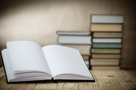 Open book on wood desk with blurred focus for background.  の写真素材