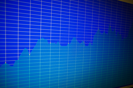 Financial graph on a computer monitor screen. Background stock chart. Analysing stock market data on a monitor. Blue background with stock chart. Finance concept. Tools of technical analysis.の写真素材