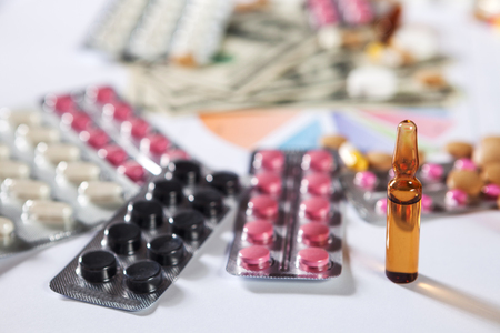 Medical marketing and healthcare business analysis report with graph and many. Pile of pills in blister packs backgroundの写真素材