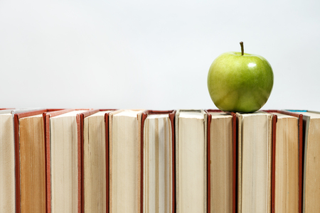 Stack of books and apple on the table. Copy space for text. Selective focus. Knowledge conceptの写真素材