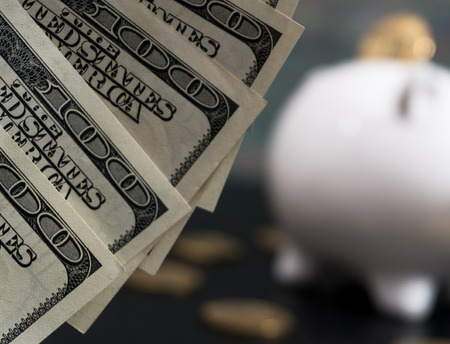 White piggy bank with one gold bitcoin coin new virtual money on a colored wooden backgroundの写真素材
