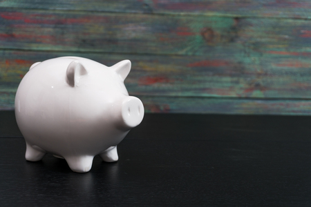 White Piggy bank on a colored wooden background.の写真素材