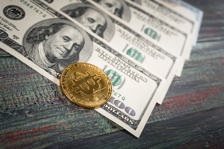 Bitcoin and money on a colored wooden background. Bitcoin golden coin New virtual moneyの写真素材