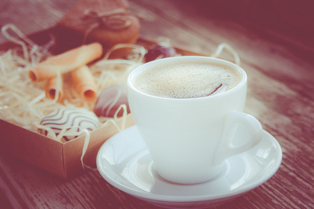 White cup of coffee on a natural old wooden background with biscuits. Selective focus. With copy spaceの写真素材