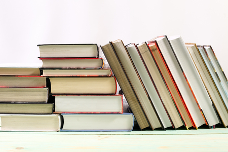 Pile of various books on wooden background. With copy space for your textの写真素材