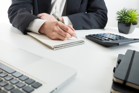 Close up view of bookkeeper or financial inspector hands making report, calculating or checking balance.の写真素材