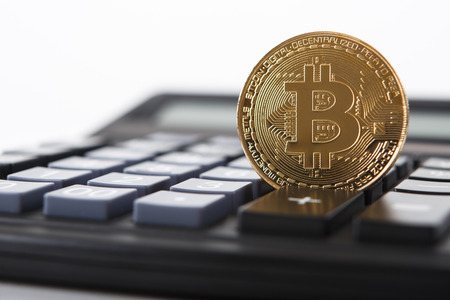 Bitcoin on the keyboard of the calculator. Shallow depth of field. A visual representation of digital cryptocurrencies.の写真素材