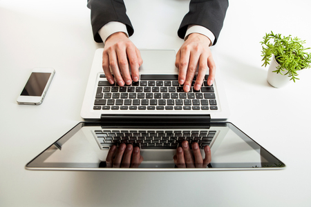 Man hand on laptop keyboard with blank screen monitorの写真素材