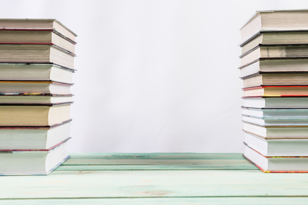 Pile of various books on bright wooden background. With copy space for your textの写真素材