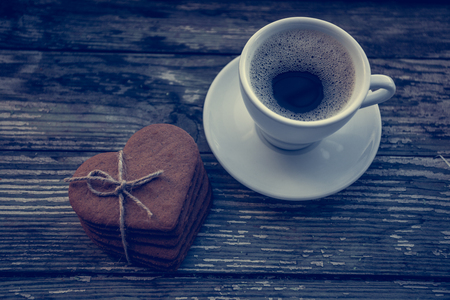 White cup of coffee on a natural old wooden background with biscuits. Selective focus. With copy spaceの写真素材