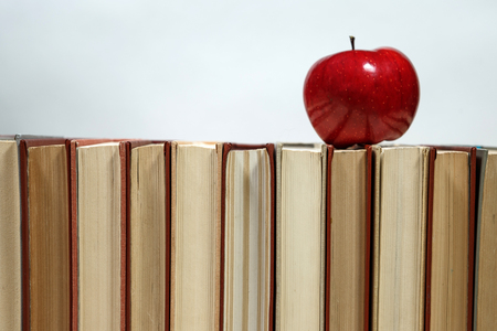 Stack of books and apple on the table. Copy space for text. Selective focus. Knowledge conceptの写真素材