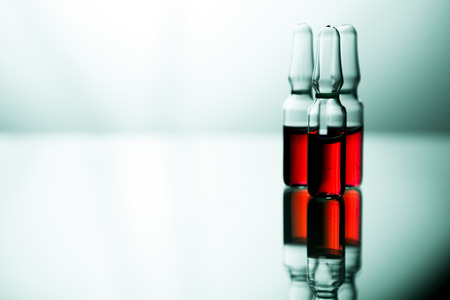 Ampoules with red liquid. On white background close up.の写真素材