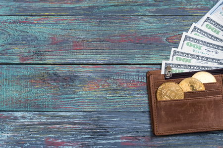 Bitcoin and money in a purse on a colored wooden background. Bitcoin golden coin New virtual moneyの写真素材