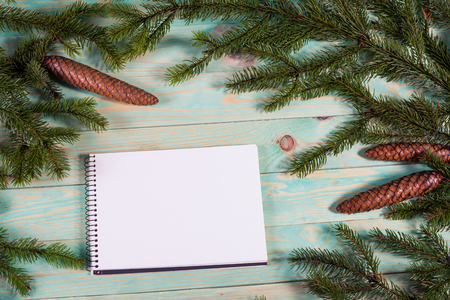 Christmas background with spruce branches on wooden board with notebook copy spaceの写真素材