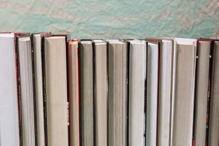 Pile of various books on bright wooden background. With copy space for your textの写真素材