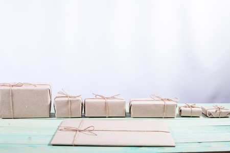 Presents for any holiday concept. Border of decorative gifts wrapped kraft paper tied with tourniquet for christmas, valentine day or birthdayの写真素材