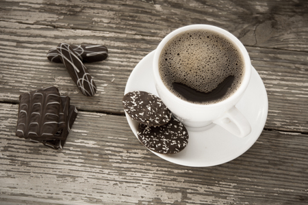 White cup of coffee on a natural old wooden background with biscuits. Selective focus. With copy spaceの写真素材