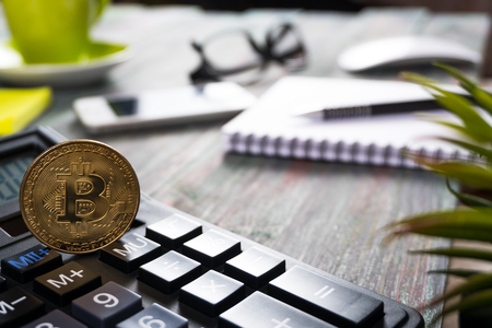 Bitcoin and keyboard calculator in a business office. Bitcoin golden coin New virtual moneyの写真素材