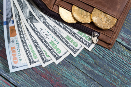 Bitcoin and money in a purse on a colored wooden background. Bitcoin golden coin New virtual moneyの写真素材