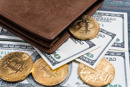 Bitcoin and money in a purse on a colored wooden background. Bitcoin golden coin New virtual moneyの写真素材
