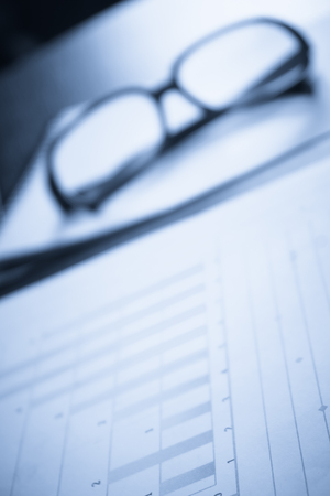 Business accessories on a background of diagramsの写真素材