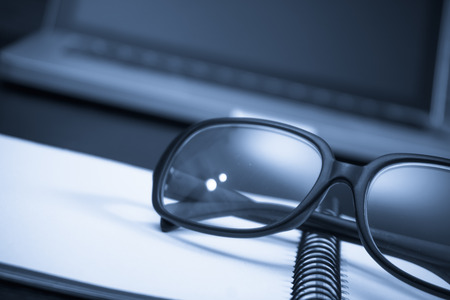 Black framed glasses on the computer keyboard with a very shallow depth of field. Copy space for textの写真素材