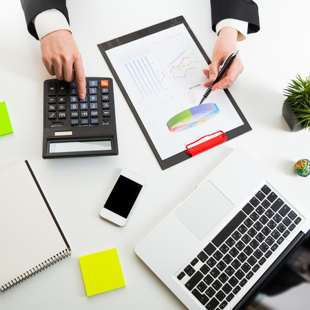 Close up view of bookkeeper or financial inspector hands making report, calculating or checking balance. Marketing strategy brainstorming. Paperwork and digital in office.の写真素材