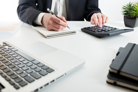 Close up view of bookkeeper or financial inspector hands making report, calculating or checking balance. Marketing strategy brainstorming. Paperwork and digital in office.の写真素材