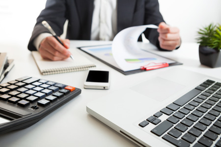 Close up view of bookkeeper or financial inspector hands making report, calculating or checking balance. Marketing strategy brainstorming. Paperwork and digital in office.の写真素材