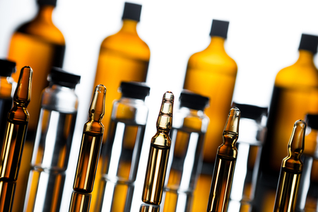 Group of ampoules with a transparent medicine in medical laboratory. lot of ampoules on light background.の写真素材