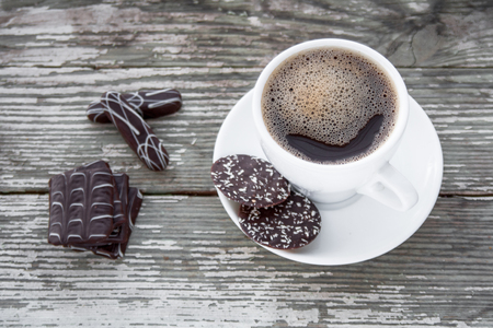 White cup of coffee on a natural old wooden background with biscuits. Selective focus. With copy spaceの写真素材