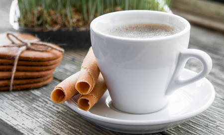 White cup of coffee on a natural old wooden background with biscuits. Selective focus. With copy spaceの写真素材