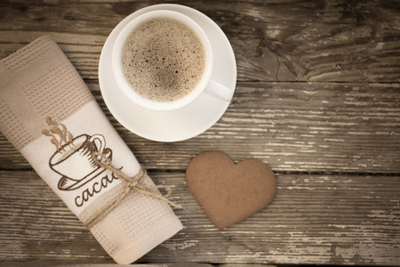 White cup of coffee on a natural old wooden background with biscuits. Selective focus. With copy spaceの写真素材