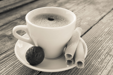 White cup of coffee on a natural old wooden background with biscuits. Selective focus. With copy spaceの写真素材