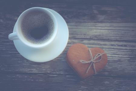 White cup of coffee on a natural old wooden background with biscuits. Selective focus. With copy spaceの写真素材