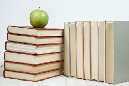Stack of books and apple on the table. Copy space for text. Selective focus. Knowledge conceptの写真素材