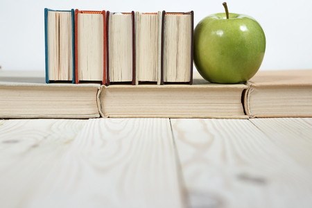 Stack of books and apple on the table. Copy space for text. Selective focus. Knowledge conceptの写真素材