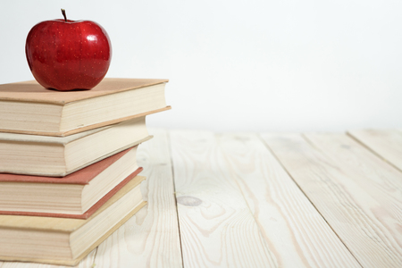 Stack of books and apple on the table. Copy space for text. Selective focus. Knowledge conceptの写真素材