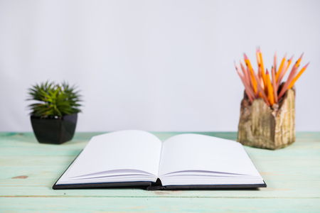 Set of pencils and pile of various books on wooden background. With copy space for your textの写真素材